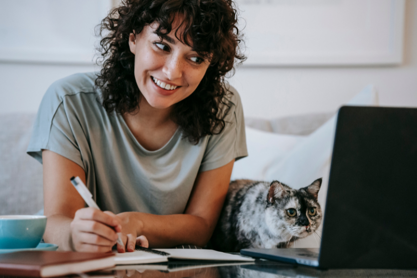 woman and a cat looking at a laptop